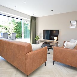 Helles Wohnzimmer mit Blick auf die Terrasse im Bungalow 't Hoogelandt 58, De Dennen Texel.