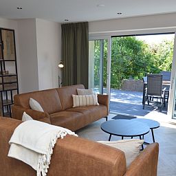 Modernes Wohnzimmer mit Zugang zur Terrasse im Bungalow 't Hoogelandt 58, De Dennen Texel.