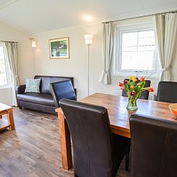 Cozy living room in Holiday Park De Koorn-aar Type F, Texel, with comfortable sitting area and dining area.