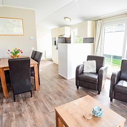 Spacious indoor room with dining and sitting area in Holiday Park De Koorn-aar Type F, Texel, Wadden Islands.