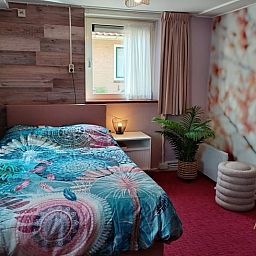 Gezellige slaapkamer met kleurrijk dekbedovertrek in vakantiehuis Oosterend, Terschelling.