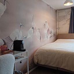 Slaapkamer met elegant vogelbehang in Huisje in Oosterend, Terschelling.