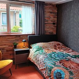 Knusse slaapkamer met houten accenten in vakantiehuis Oosterend, Waddeneilanden.