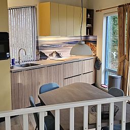 Sunny terrace at Glissando bungalow, Midsland Noord, Terschelling with parasol and garden table.