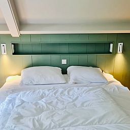 Comfortabele slaapkamer in vakantiehuisje in Ballum, Ameland met sfeervolle verlichting.