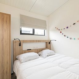 Attraktives Schlafzimmer im Ferienhaus Kooikers Comfort, Hollum, Ameland, mit bequemem Bett und moderner Einrichtung auf den Watteninseln.
