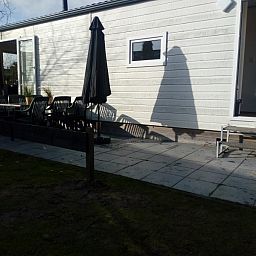 Sonnige Terrasse des Protter-Chalets in Buren, Ameland, ideal fr ein Frhstck im Freien auf den Watteninseln.