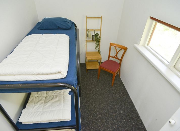 Rustikales Aeusseres des Coming Well Ferienhauses in De Cocksdorp, Texel mit gruener Umgebung.