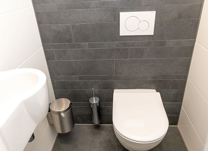 Dining room in De Jutter vacation home De Cocksdorp Texel overlooking green garden.