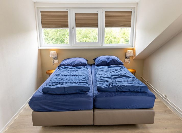 Dining room in De Jutter vacation home De Cocksdorp Texel overlooking green garden.
