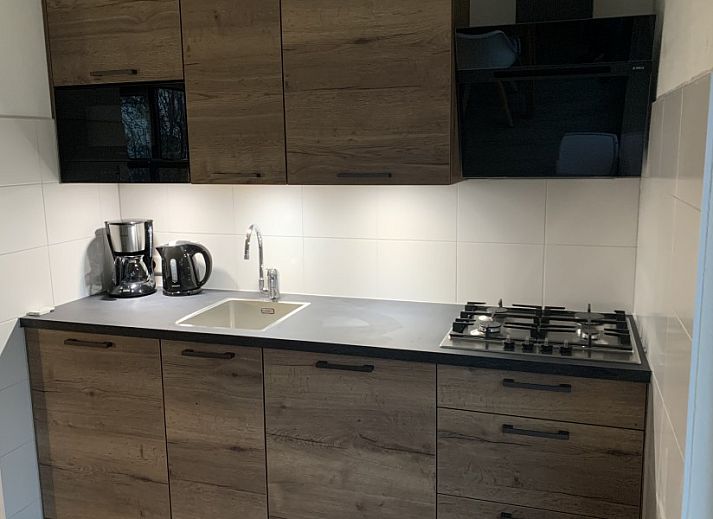 Side view of La Guitarra vacation home in De Cocksdorp Texel with terrace and garden.