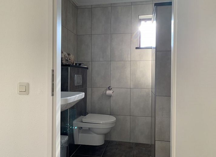 La Guitarra in De Cocksdorp Texel, vacation home with green fence and entrance gate.