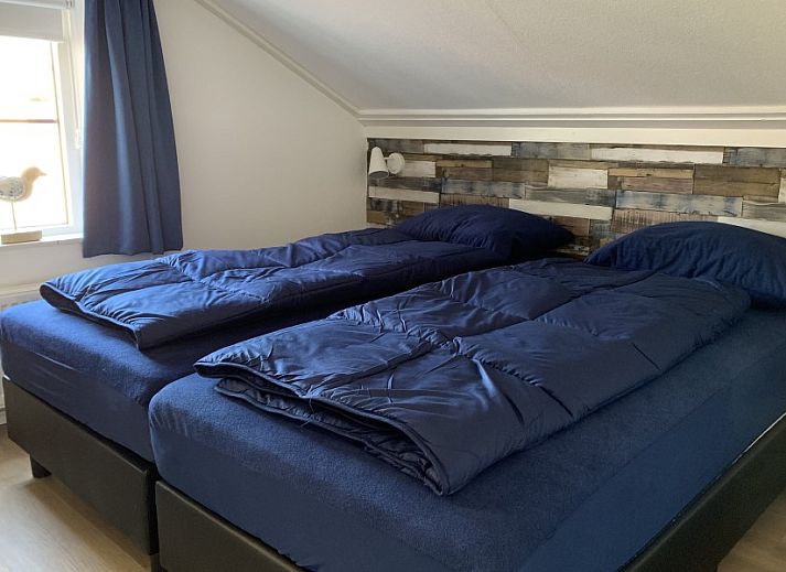 Cozy living room of La Guitarra vacation home in De Cocksdorp Texel with fireplace.