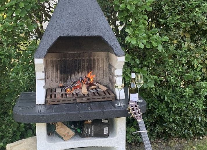 Comfortable seating area in La Guitarra vacation home in De Cocksdorp Texel overlooking garden.
