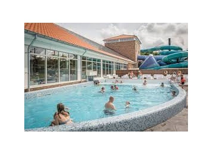 Comfortable seating area in La Guitarra vacation home in De Cocksdorp Texel overlooking garden.