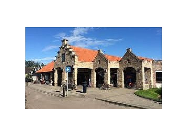 La Guitarra Texel, dining area with large table and garden view in De Cocksdorp.