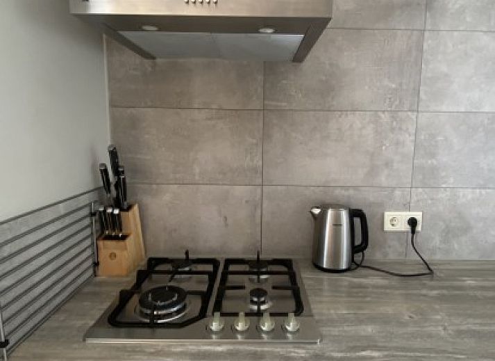 Terrasse mit bequemen Stuehlen in der Luxe 8 persoons Golf Villa Texel, umgeben von Natur in De Cocksdorp.