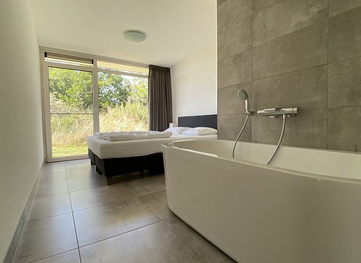 Terrasse mit bequemen Stuehlen in der Luxe 8 persoons Golf Villa Texel, umgeben von Natur in De Cocksdorp.