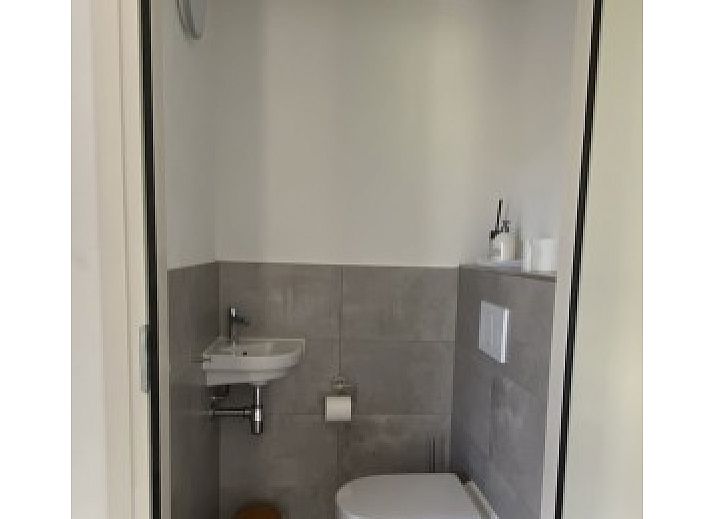 Gemuetliches Wohnzimmer der Luxe 8 Persoons Golf Villa Texel in De Cocksdorp mit Blick auf den Garten.