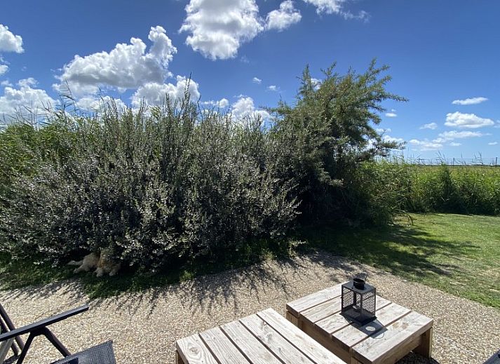 Gemuetliches Wohnzimmer der Luxe 8 Persoons Golf Villa Texel in De Cocksdorp mit Blick auf den Garten.