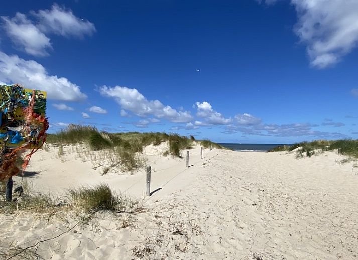 Gemuetliches Wohnzimmer der Luxe 8 Persoons Golf Villa Texel in De Cocksdorp mit Blick auf den Garten.