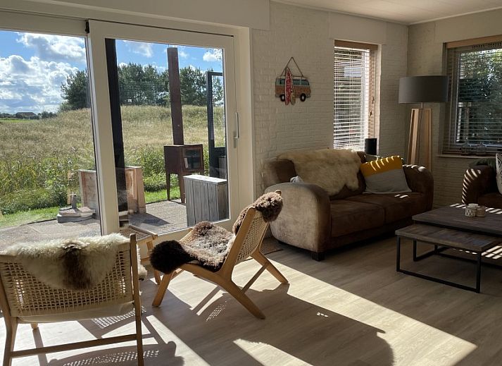 Gezellige binnenruimte van Kaap Zilt Texel vakantiehuis met wijn en kaart.