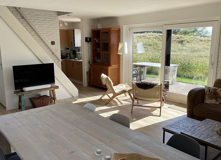 Gezellige binnenruimte van Kaap Zilt Texel vakantiehuis met wijn en kaart.