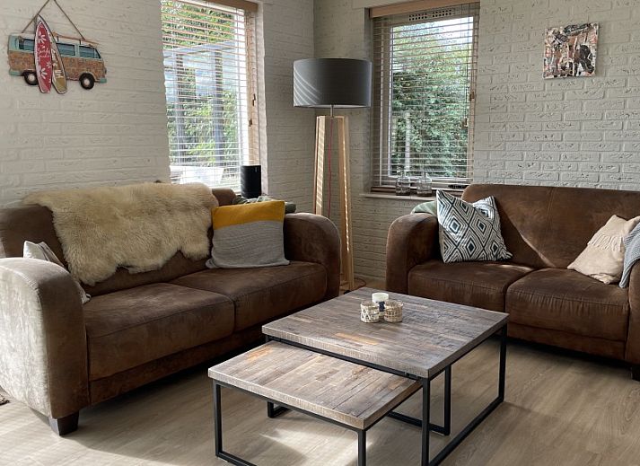 Gezellige binnenruimte van Kaap Zilt Texel vakantiehuis met wijn en kaart.