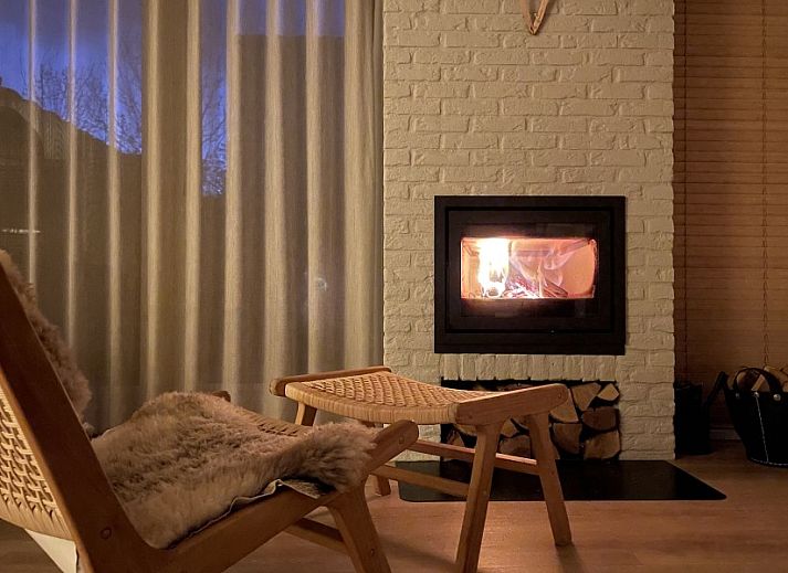 Gezellige binnenruimte van Kaap Zilt Texel vakantiehuis met wijn en kaart.