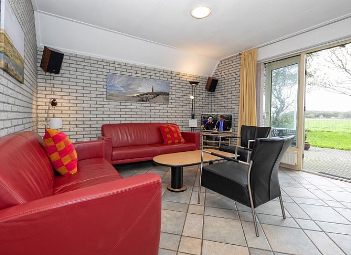 Ferienhaus Schelpenoord 129 in De Cocksdorp, Texel mit schoener Fassade und geraeumiger Veranda.