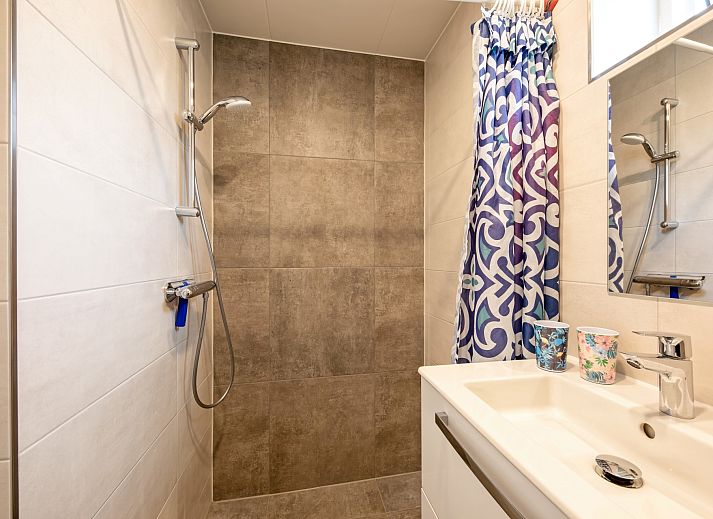 Esszimmer und Kueche im Ferienhaus Slufterhoek 150, De Cocksdorp Texel, mit Blick in den Garten.