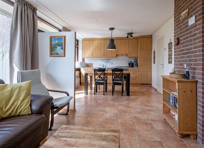 Gemuetliches Wohnzimmer des Ferienhauses Slufterhoek 100 in De Cocksdorp, Texel, mit Blick auf die Natur.