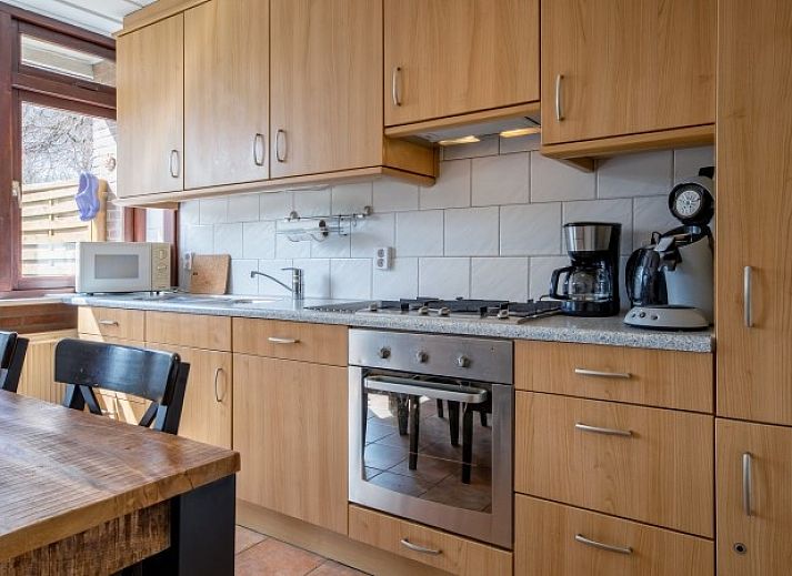 Gemuetliches Wohnzimmer des Ferienhauses Slufterhoek 100 in De Cocksdorp, Texel, mit Blick auf die Natur.