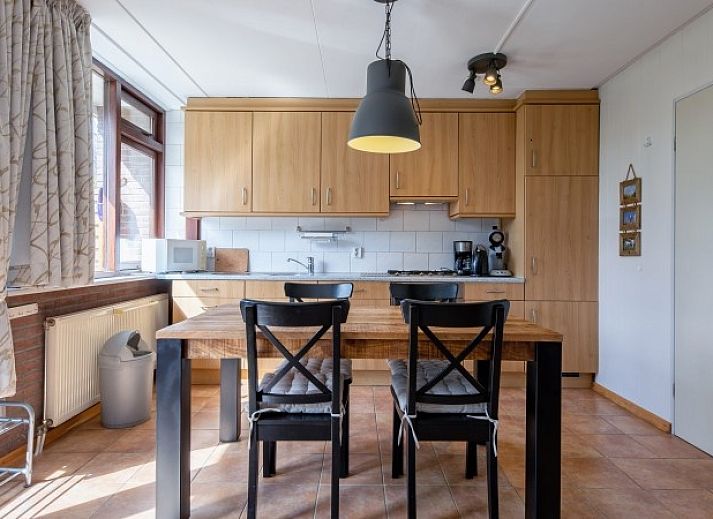 Gemuetliches Wohnzimmer des Ferienhauses Slufterhoek 100 in De Cocksdorp, Texel, mit Blick auf die Natur.