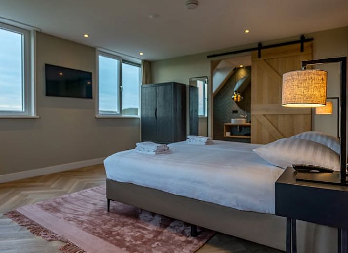 Charmantes Aeusseres des Ferienhauses in De Cocksdorp, Texel, mit roten Dachziegeln.