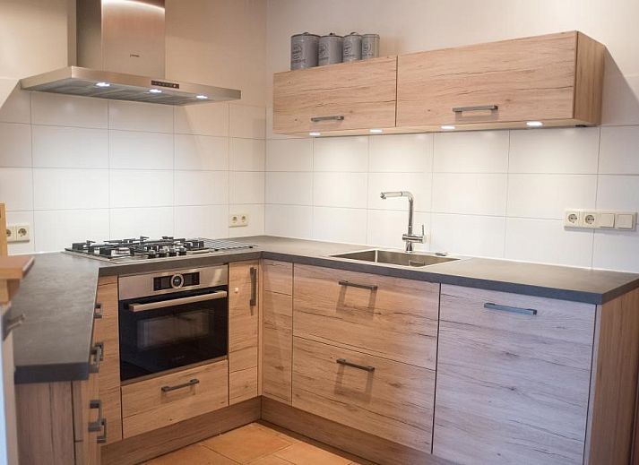 Gezellige woonkamer van Velduil vakantiehuis in De Cocksdorp, Texel met open haard.