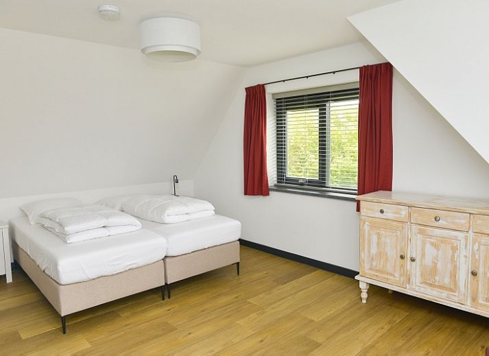 Eingang zum Ferienhaus De Postschipper in De Cocksdorp, Texel, umgeben von Gruenanlagen.