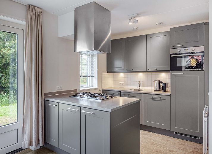 Cozy living room in Sluftervallei 8-person bungalow, De Cocksdorp, Texel with comfortable sitting area and cozy fireplace.