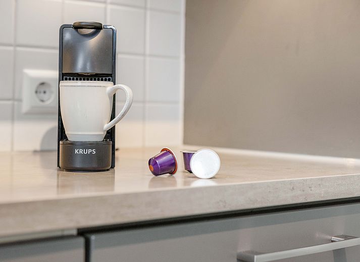 Cozy living room in Sluftervallei 8-person bungalow, De Cocksdorp, Texel with comfortable sitting area and cozy fireplace.