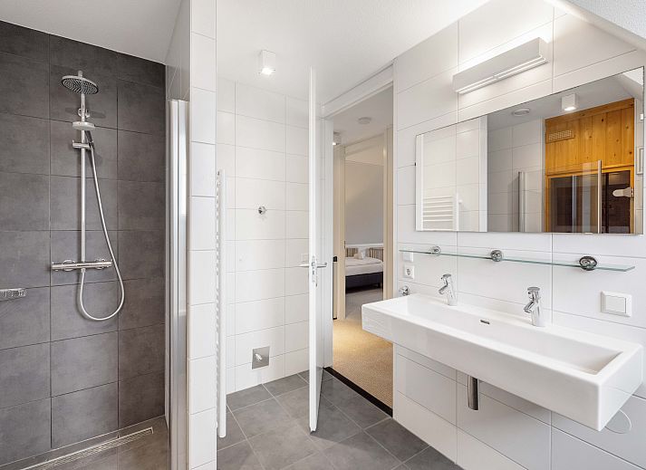 Cozy living room in Sluftervallei 8-person bungalow, De Cocksdorp, Texel. Comfortable sitting area with fireplace and views of nature.