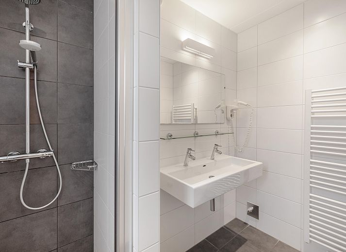 Cozy living room in Sluftervallei 8-person bungalow, De Cocksdorp, Texel. Comfortable sitting area with fireplace and views of nature.