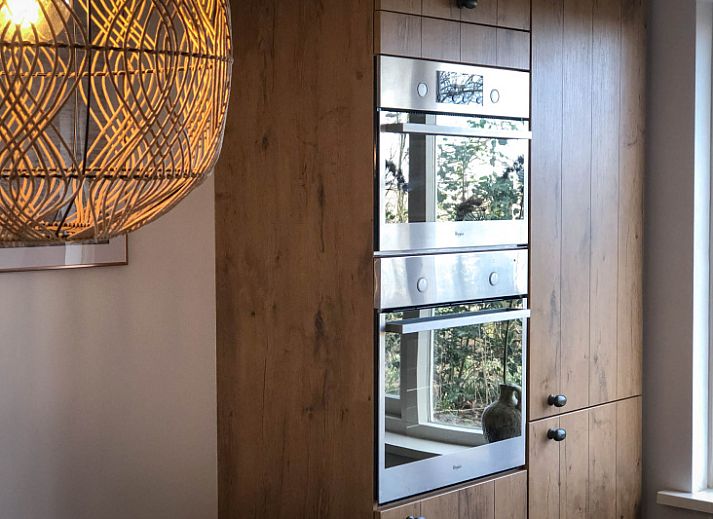 Stijlvolle woonkamer in Vakantiehuis De Vuurtoren, De Cocksdorp, Texel met comfortabele banken.