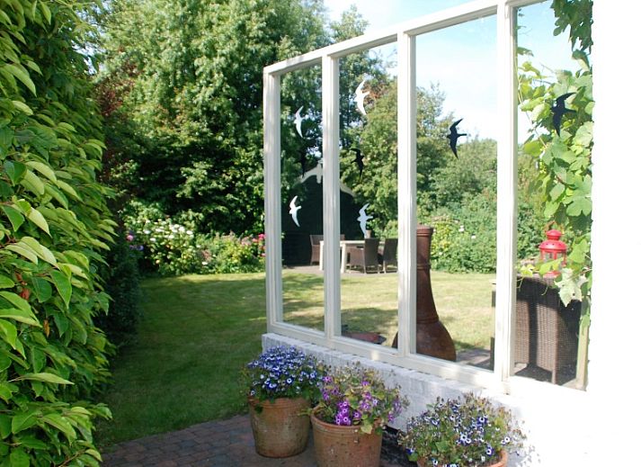 The Wulpenlied vacation home in De Cocksdorp, Texel, surrounded by greenery and flowers.