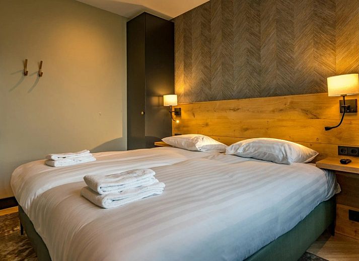 Illuminated evening view of 6 person vacation home in De Cocksdorp Texel with terrace.