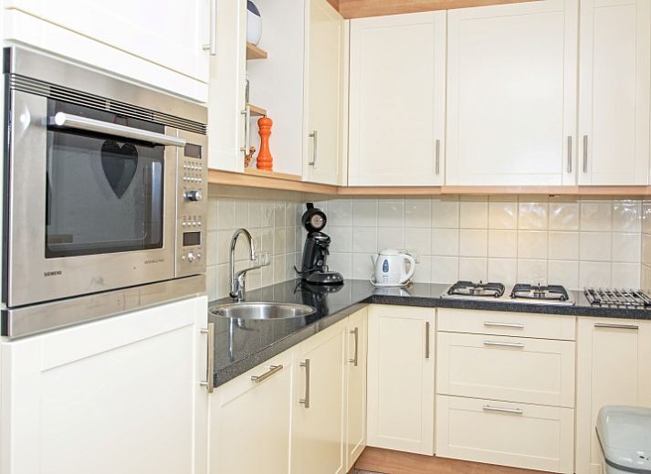 Ferienhaus Slufterduin 076 in De Cocksdorp, Texel mit schoener Aussenfassade und Terrasse, ideal fuer einen erholsamen Aufenthalt auf den Watteninseln.