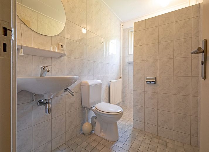 Helles Wohnzimmer des Ferienhauses Slufterduin 128 in De Cocksdorp, Texel mit Gartenblick.