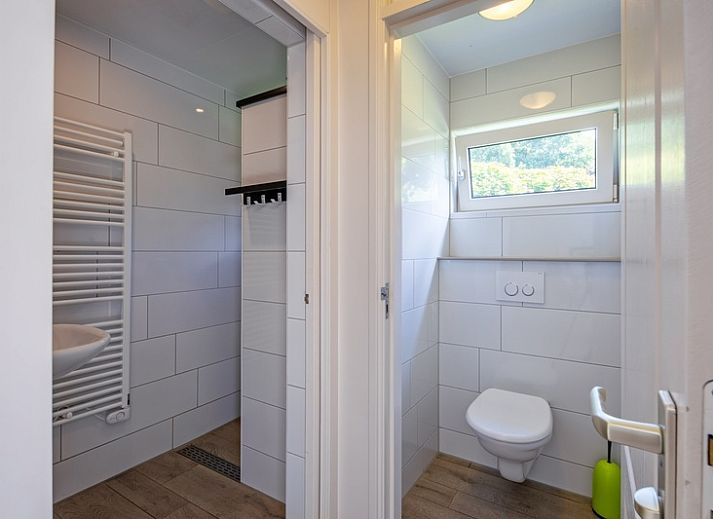 Helles und offenes Interieur des Ferienhauses Slufterhoek 174 in De Cocksdorp, Texel, mit modernen Moebeln und grossen Fenstern.