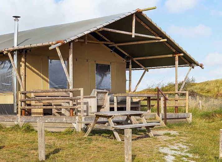 Sluftervallei safari tent in De Cocksdorp, Texel, with wooden veranda and view of dunes.