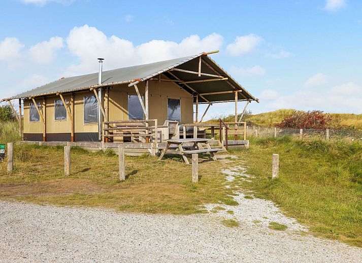 Sluftervallei safari tent in De Cocksdorp, Texel, with wooden veranda and view of dunes.