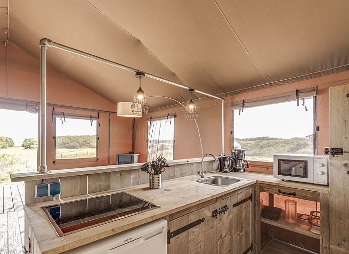 Spacious living room in Sluftervallei glamping lodge, Texel, overlooking nature.